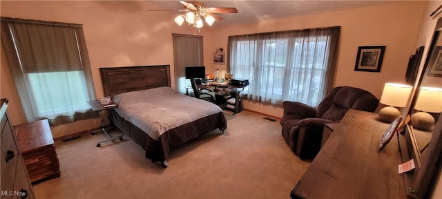 bedroom featuring baseboards, light colored carpet, ceiling fan, and visible vents