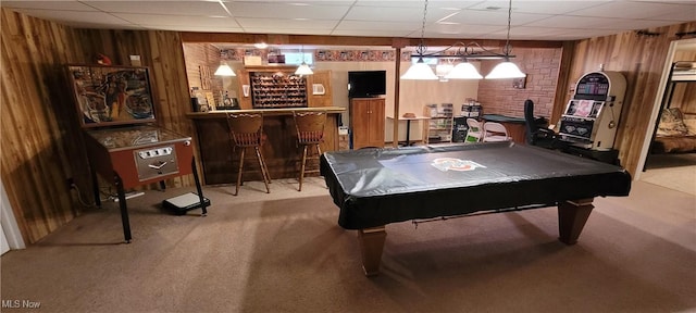 playroom featuring carpet flooring, a dry bar, wooden walls, a drop ceiling, and pool table