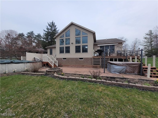 back of house featuring a patio, a yard, a wooden deck, and stairs