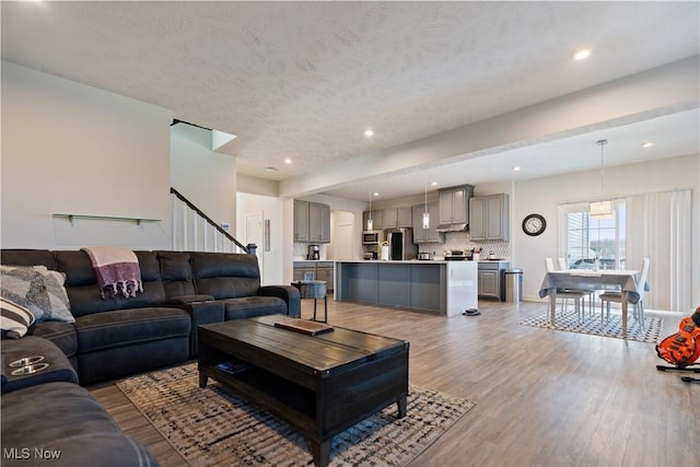 5454 Schueller Blvd, Sheffield Village, OH 44054 - living room with recessed lighting, stairway, light wood-type flooring, and a textured ceiling