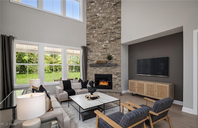 3691 Summerfield Ln, Richfield, OH 44286 - living room featuring a stone fireplace, a towering ceiling, wood finished floors, and baseboards