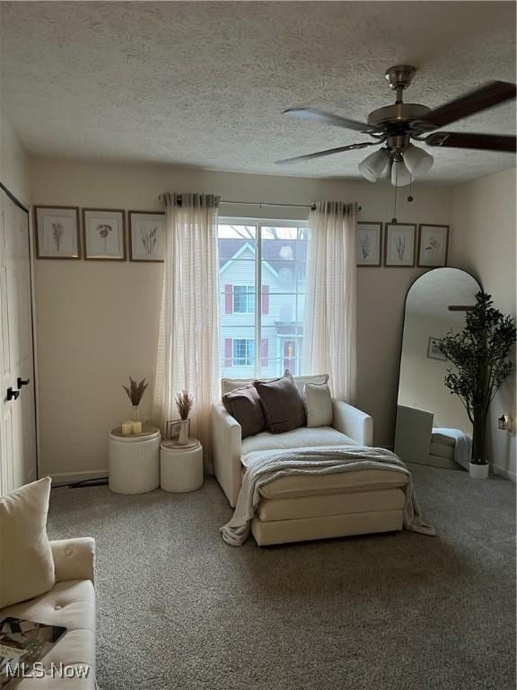 bedroom featuring a ceiling fan, carpet, and a textured ceiling