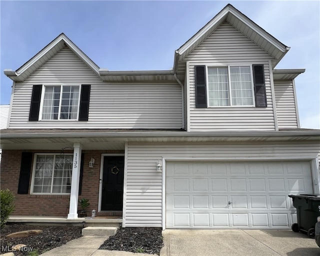 traditional-style home featuring a garage, brick siding, driveway, and covered porch
