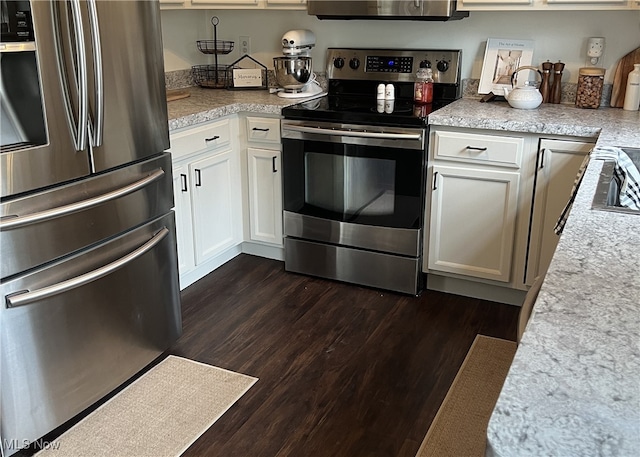 kitchen with appliances with stainless steel finishes, light countertops, dark wood finished floors, and white cabinets