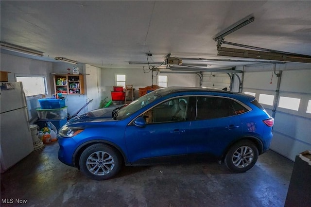 8672 Ridgeview Rd, Chandlersville, OH 43727 - garage featuring a garage door opener and freestanding refrigerator