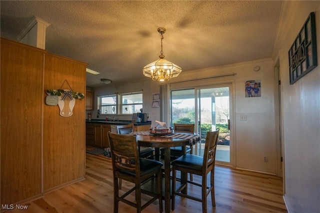 8672 Ridgeview Rd, Chandlersville, OH 43727 - dining room with a textured ceiling, a chandelier, light wood-type flooring, and crown molding