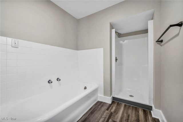 full bathroom with baseboards, a shower, wood finished floors, and a garden tub