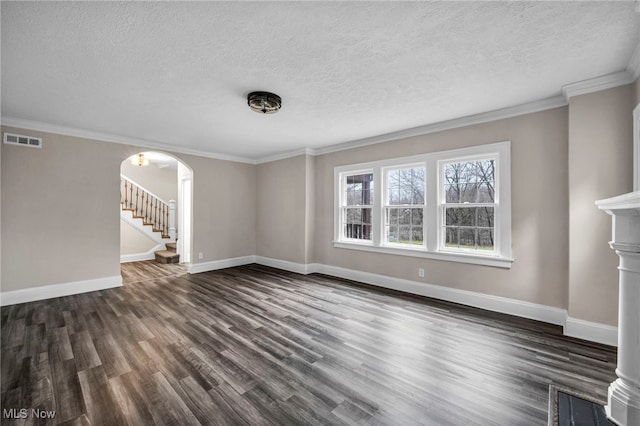 unfurnished living room featuring dark wood-type flooring, arched walkways, ornamental molding, visible vents, and baseboards