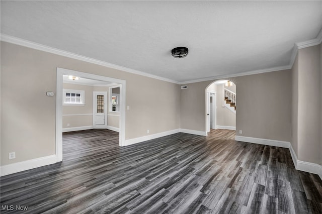 unfurnished living room featuring dark wood-type flooring, baseboards, and arched walkways