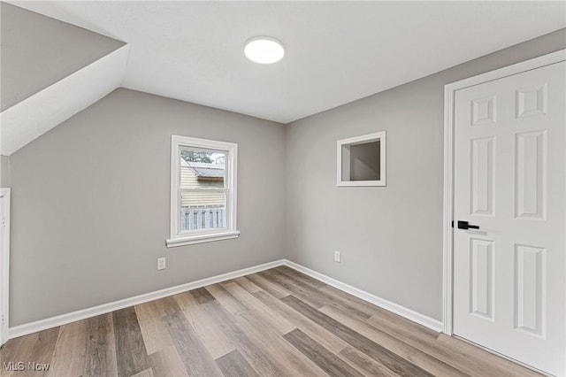 additional living space with lofted ceiling, baseboards, and wood finished floors