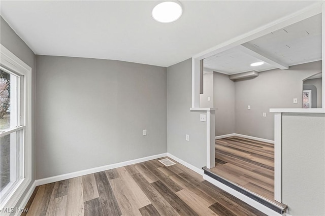below grade area with wood finished floors, baseboards, and visible vents