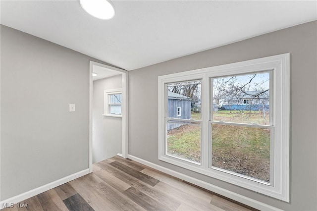unfurnished room featuring baseboards and wood finished floors