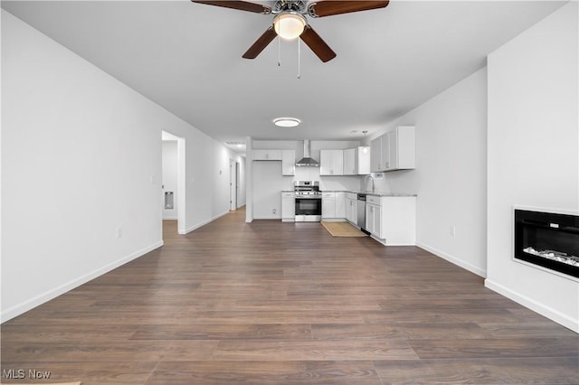 1996 E Oldgate Rd, Sandusky, OH 44870 - unfurnished living room with dark wood-type flooring, a ceiling fan, a glass covered fireplace, a sink, and baseboards