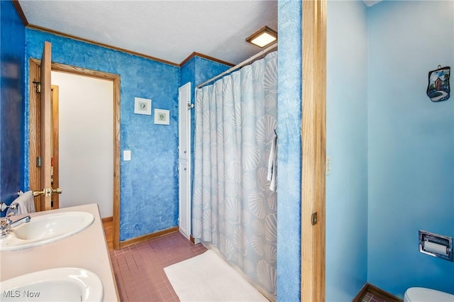 full bath with baseboards, a shower with curtain, a sink, and crown molding