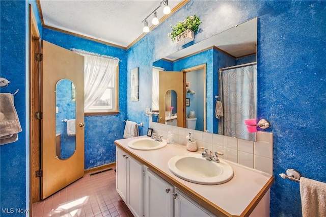 bathroom with wallpapered walls, tile patterned floors, visible vents, and a sink