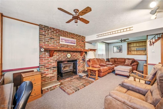 carpeted living room with a wood stove, ceiling fan, and a textured ceiling