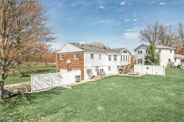 rear view of house featuring brick siding, fence, a yard, and a garage