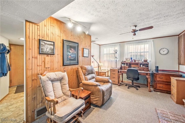 office with wooden walls, visible vents, and ceiling fan