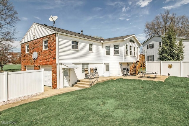 back of house featuring a yard, a patio area, a garage, fence, and brick siding