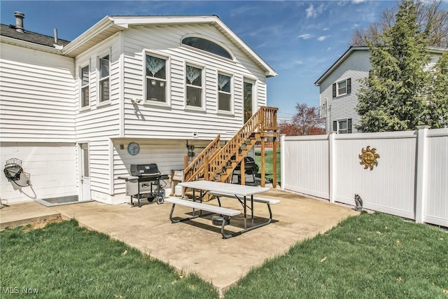 back of property with a patio, stairway, fence, and a lawn