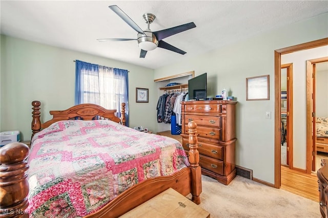 bedroom featuring light carpet, a closet, ceiling fan, and baseboards
