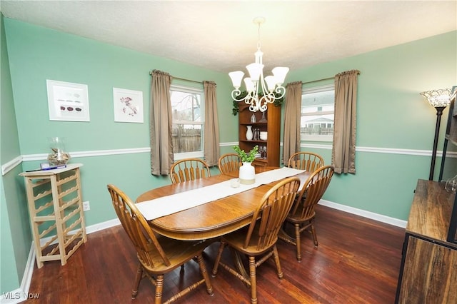 dining room with a notable chandelier, baseboards, and wood finished floors
