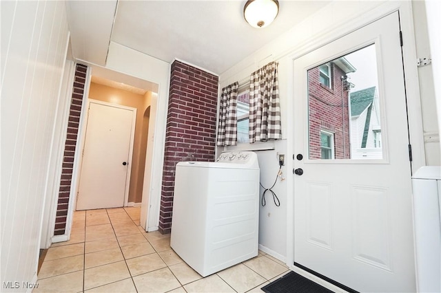 laundry room with arched walkways, washer / clothes dryer, light tile patterned floors, and laundry area