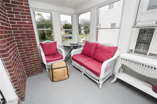 sunroom / solarium with finished concrete floors and brick wall
