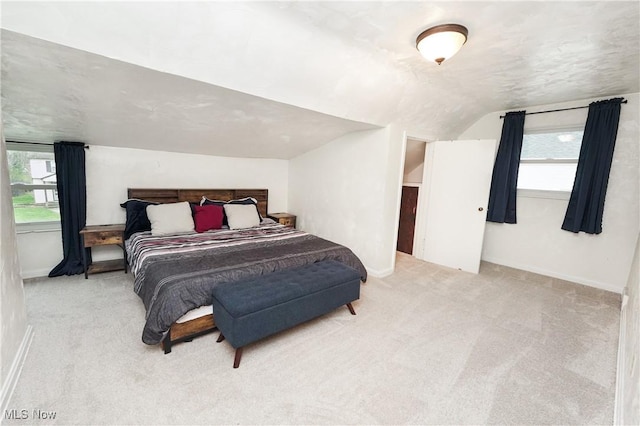carpeted bedroom with baseboards and lofted ceiling