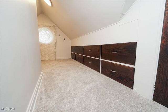 additional living space with carpet floors, baseboards, and lofted ceiling