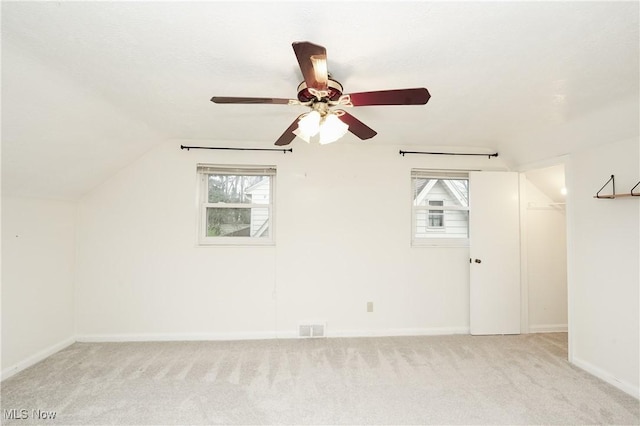 spare room with light carpet, a ceiling fan, visible vents, and plenty of natural light