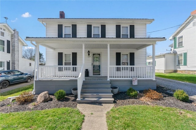 view of front of property featuring a chimney and covered porch
