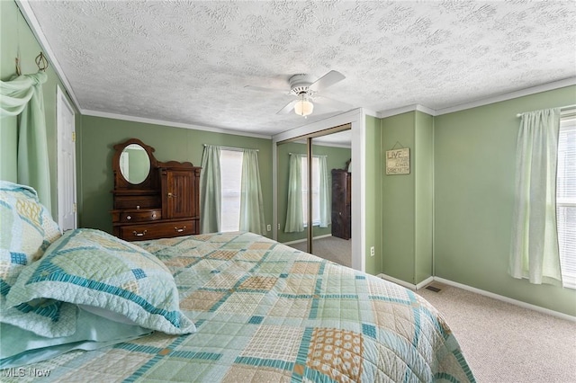 bedroom with a closet, ornamental molding, visible vents, carpet flooring, and baseboards