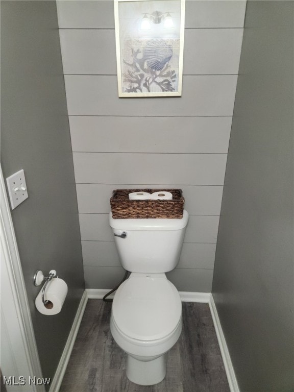 bathroom featuring toilet, wood finished floors, and baseboards