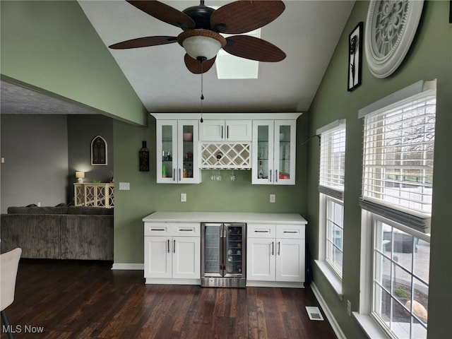 bar featuring a bar, wine cooler, dark wood-style flooring, and lofted ceiling