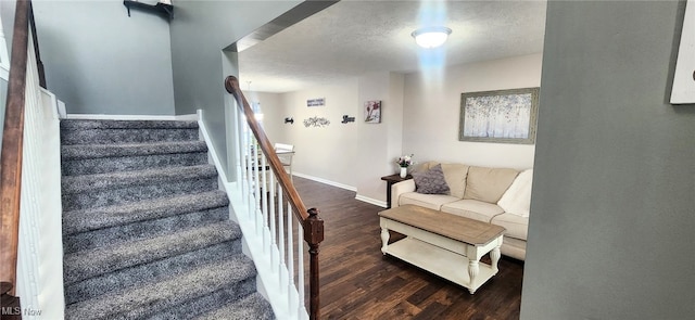 stairway with baseboards, a textured ceiling, and wood finished floors