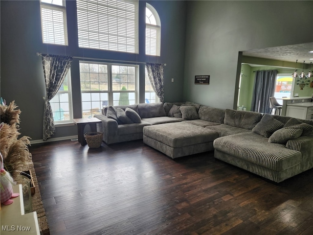 living area with wood finished floors and a towering ceiling