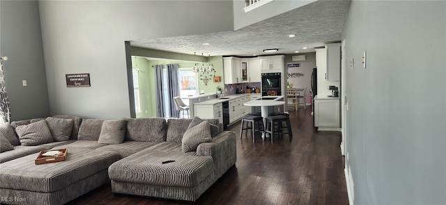 living area with dark wood-type flooring, a textured ceiling, and recessed lighting