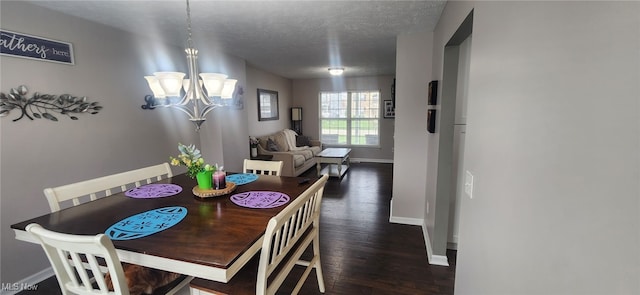 dining area featuring baseboards, a chandelier, wood finished floors, and a textured ceiling