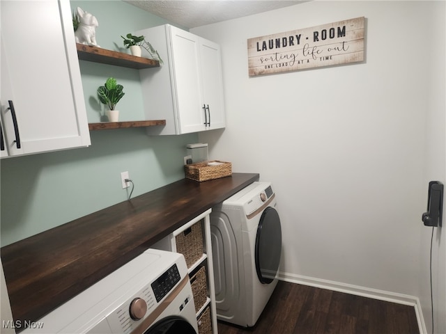 clothes washing area featuring dark wood finished floors, washer and clothes dryer, baseboards, and cabinet space