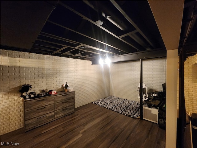 finished basement with brick wall and dark wood finished floors