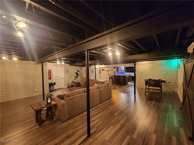 finished below grade area featuring brick wall and wood finished floors