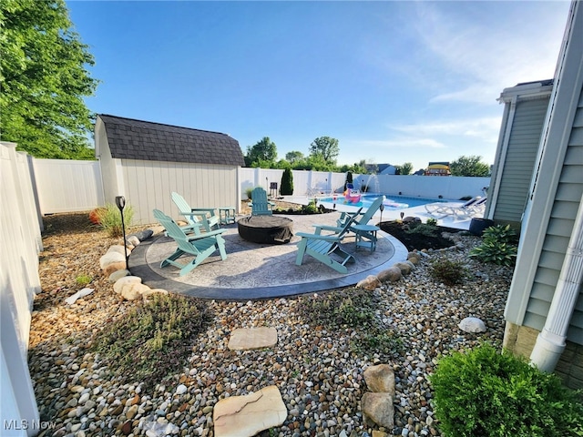 view of yard featuring a fenced in pool, a patio area, a fire pit, and a fenced backyard