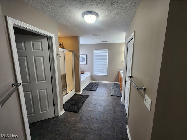 full bathroom with visible vents, baseboards, a shower stall, vanity, and a garden tub