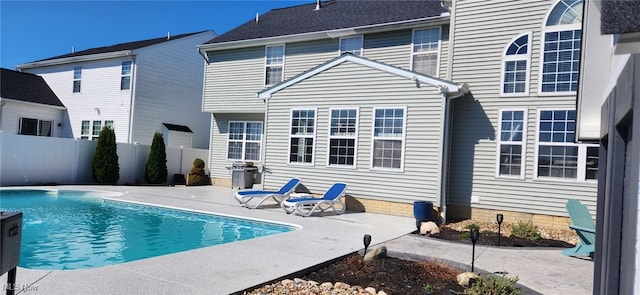 view of swimming pool featuring a fenced in pool, a patio, a fenced backyard, and grilling area