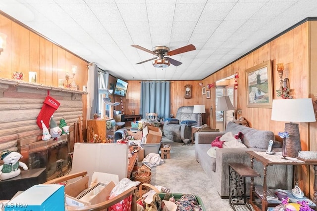 carpeted living area with wooden walls and a ceiling fan
