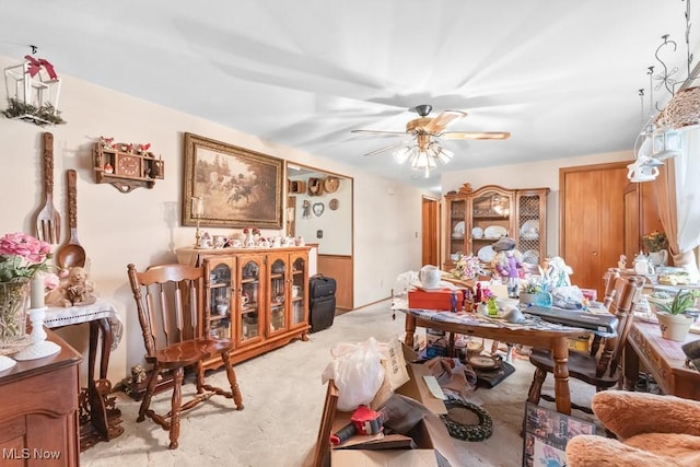carpeted dining room with ceiling fan