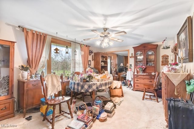 dining area featuring light carpet and a ceiling fan