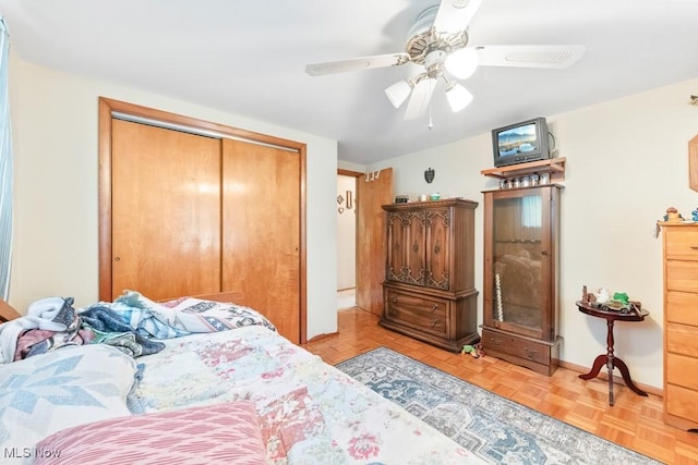 bedroom with a closet, ceiling fan, and baseboards