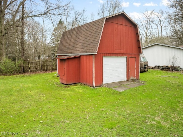 view of barn featuring a yard and fence